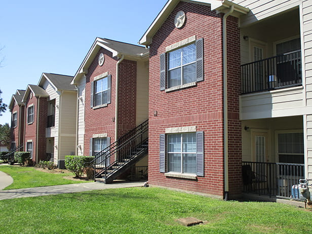 Red brick and tan sided, two-story apartment homes