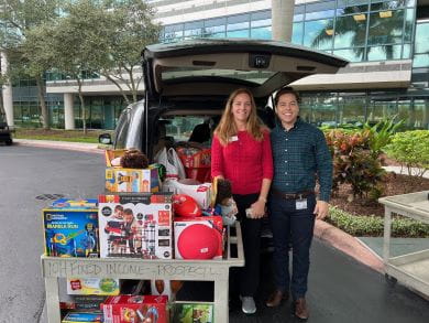 Colby Meyers, Director of Taxable Fixed Income Retail Trading, and Stacey Parker, President of the Pinellas County Foster and Adoptive Parents Association, pose in front of a car full of toy donations.