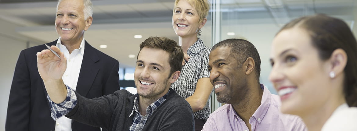 Five people smiling looking at something.