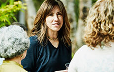 Smiling woman hanging out with friends during summer garden party