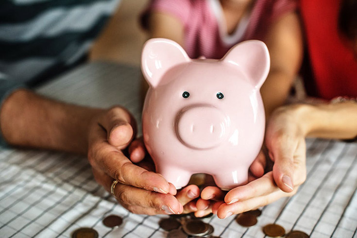 A family holding a piggy bank in their hands