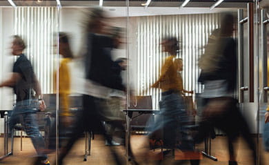 Group of office employees at coworking center. Business people walking at modern open space. Motion blur. Concept