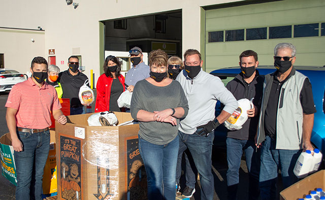 Team posing in front of food bank