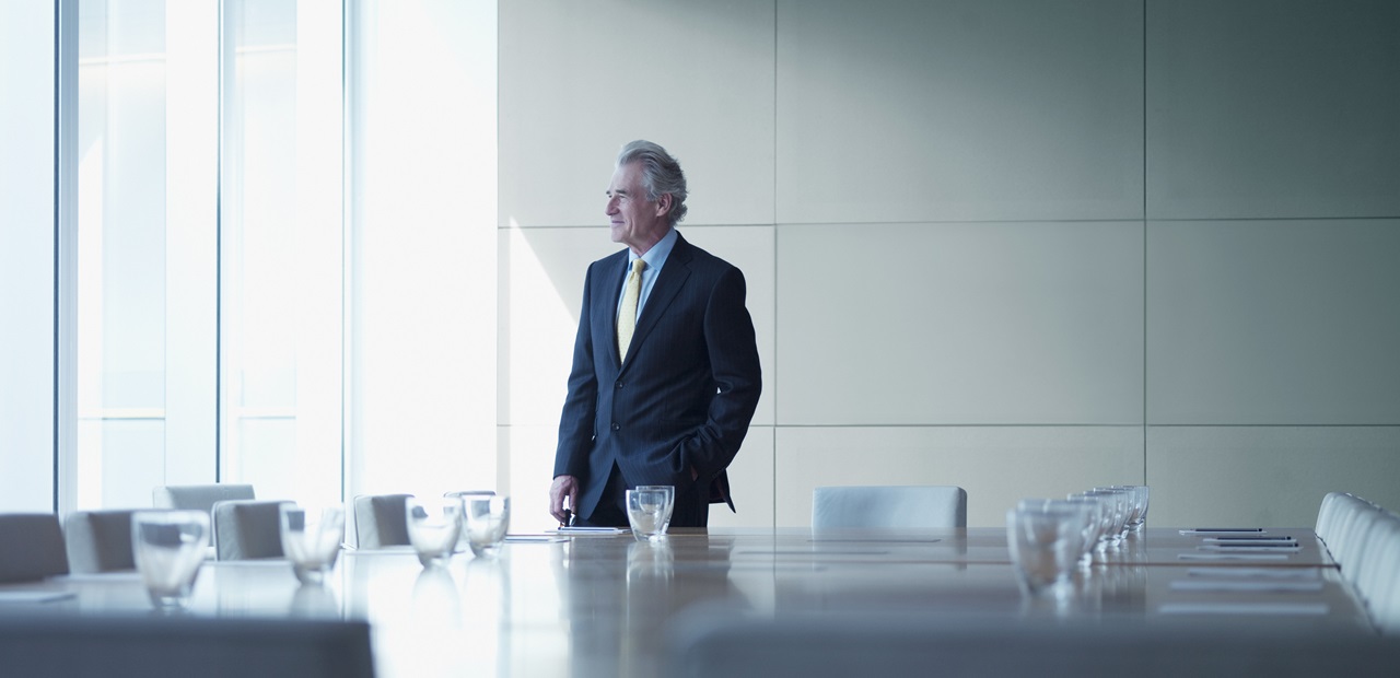 Businessman standing alone in conference room
