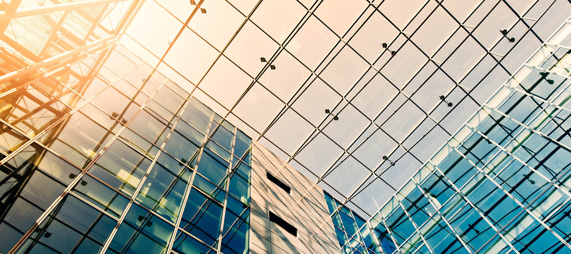 Sunny sky over steel and glass building.