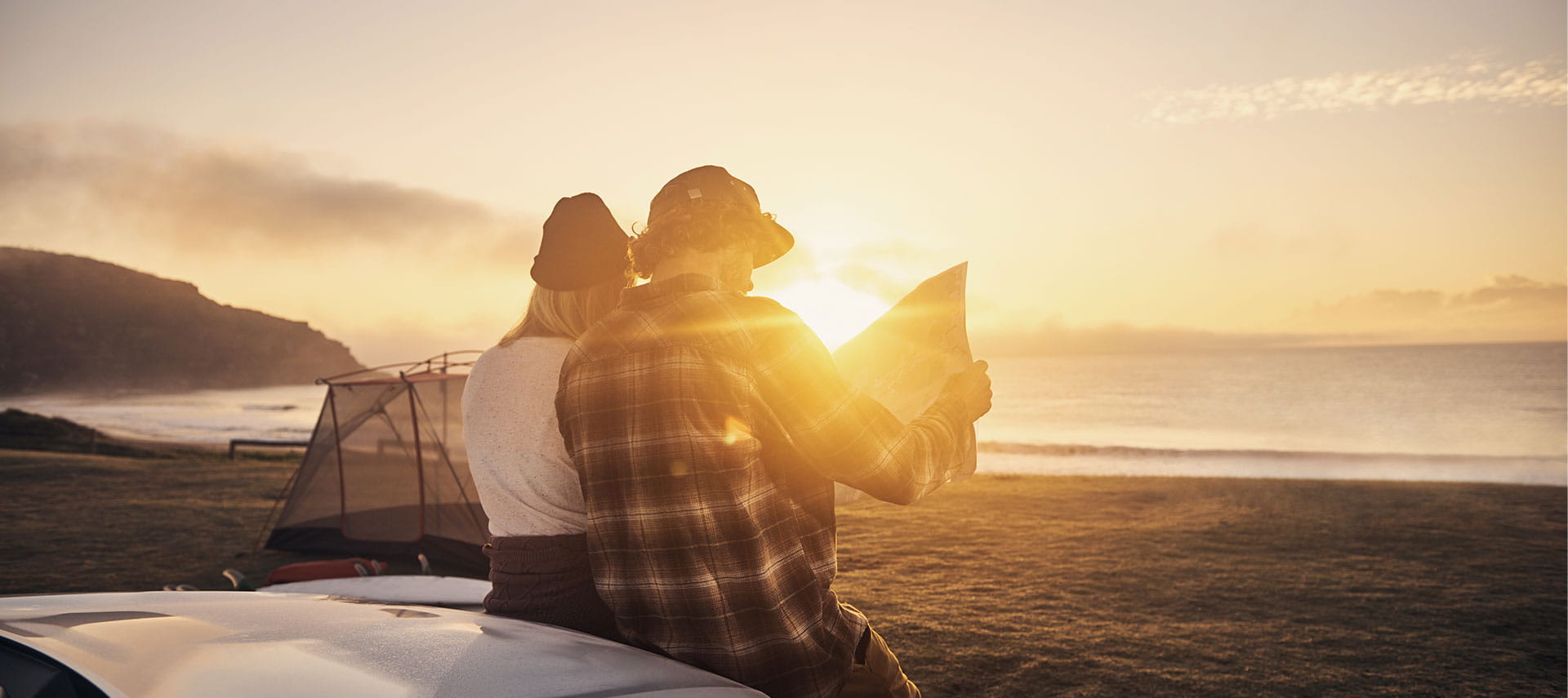 Two persons on the beach looking at a map.