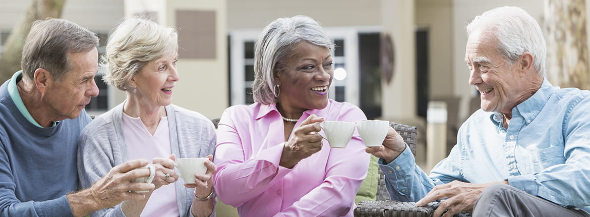 Four elderly folks having tea outside