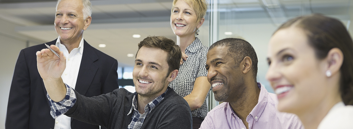 Five people smiling looking at something.