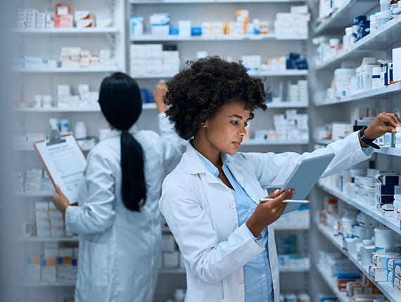Young black pharmacist taking inventory