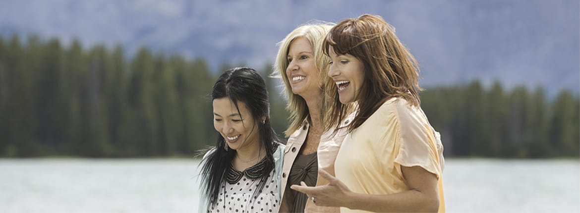 Three women standing up laughing.