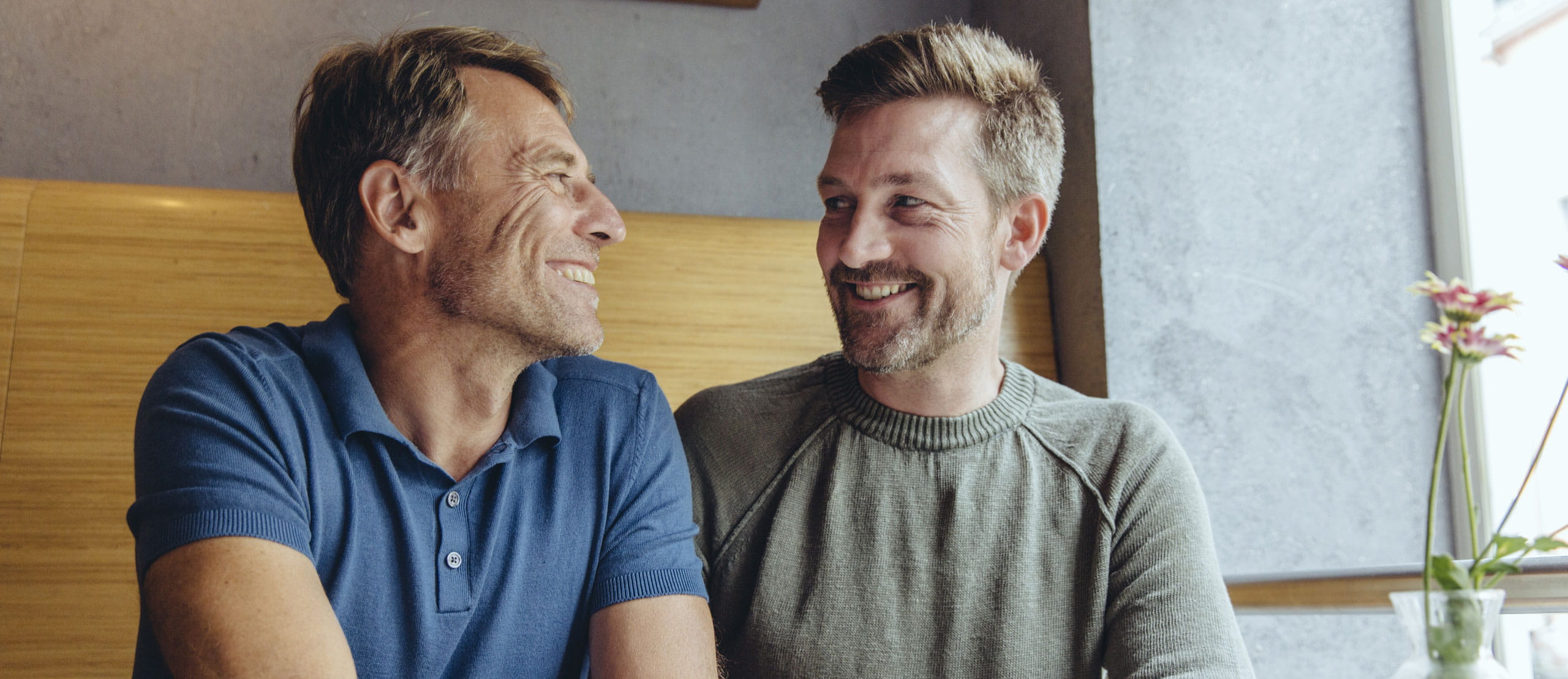 Gay couple sitting next to the window
