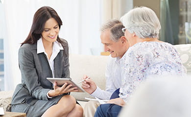 Financial advisor using tablet computer with clients