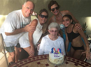 David and friends posing with a woman at her birthday celebration.