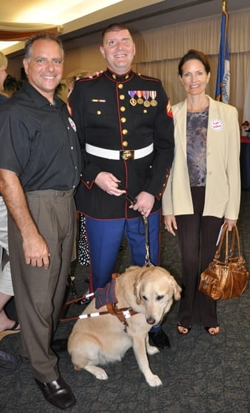 David and Kecia posing with a wounded veteran and his guide dog.