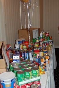 Various canned food items displayed on a table with a white tablecloth.