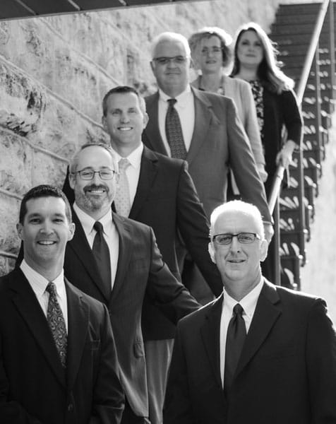 Goodwater Wealth Management Group team standing on stairs, photo is in black and white.
