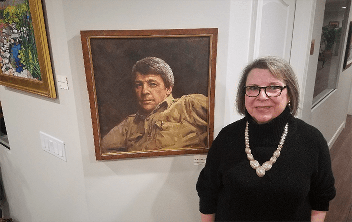 Woman standing next to a painting