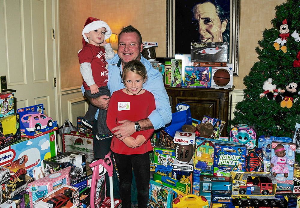 Mick with kids amidst toys and Christmas tree