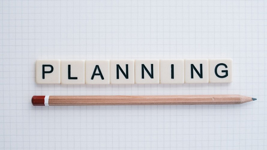 The word 'Planning' spelled in tiles above a pencil