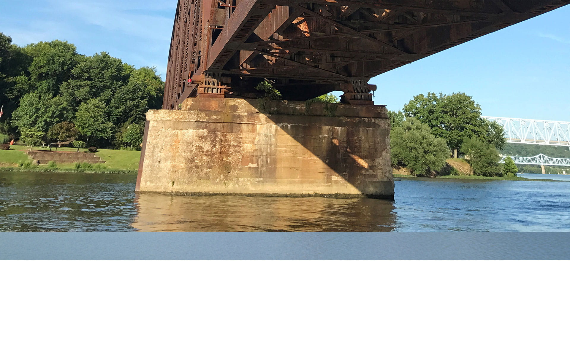Below a rusty train bridge