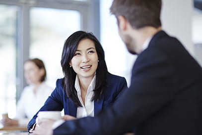 Young Asian businesswoman talking to young man