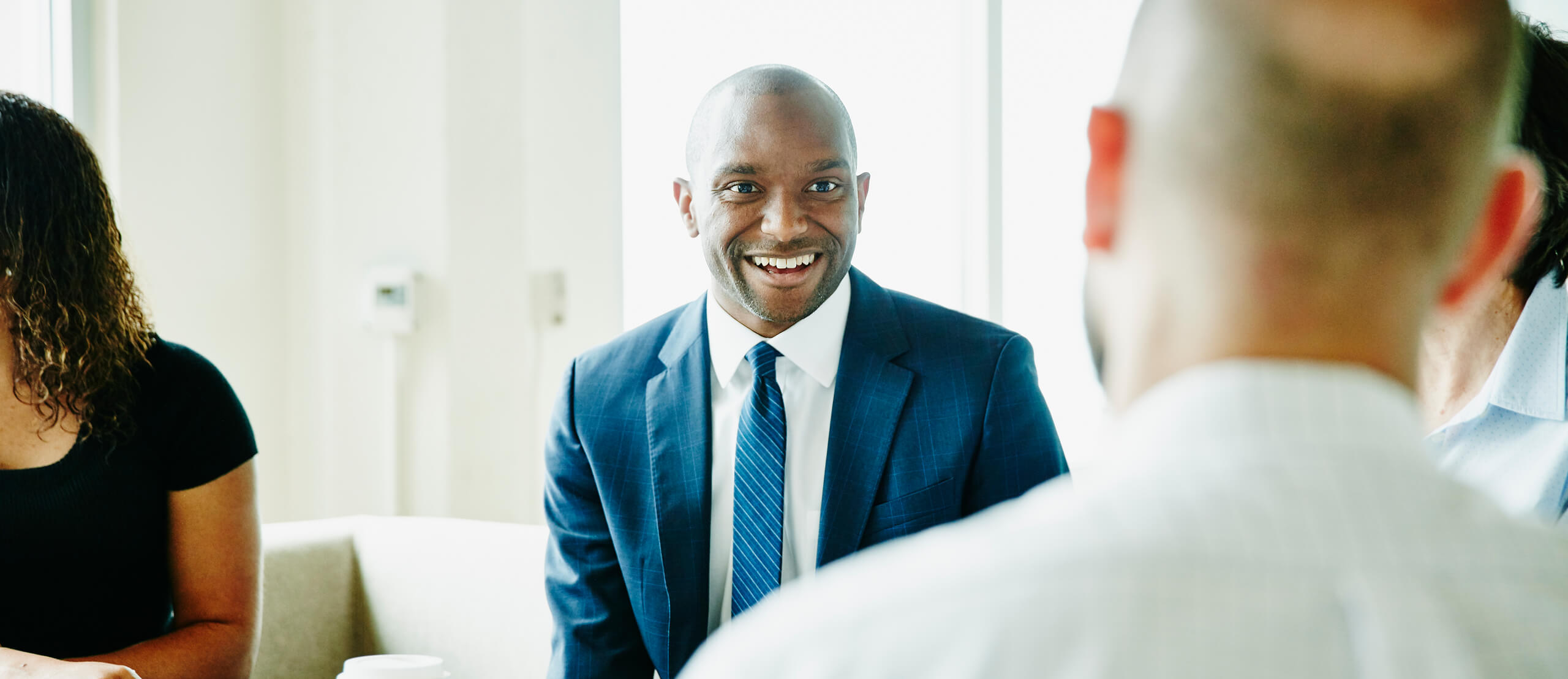 Smiling Businessman In Discussion With Colleagues