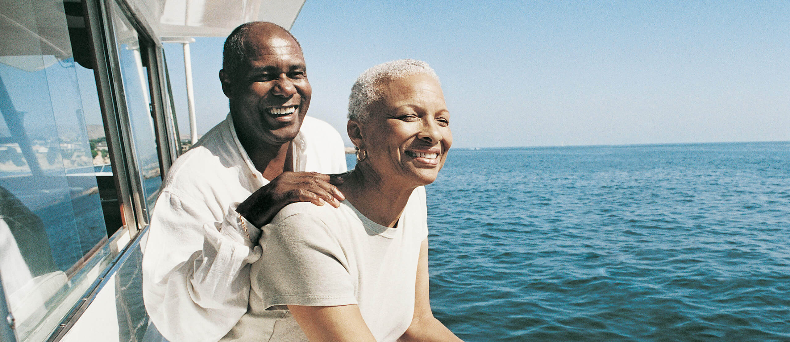 Older man and woman on a boat staring into the water