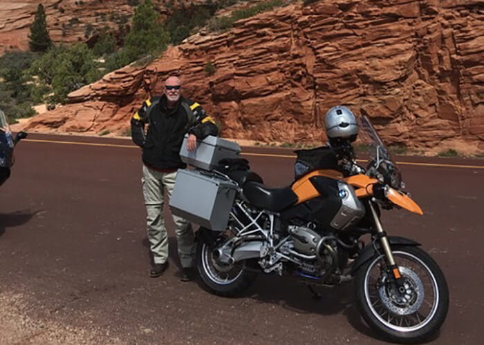 Ed posing beside a motorcycle