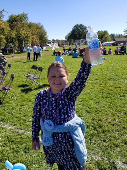 smiling girl holding bottle of water