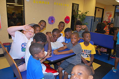 Boys pile into booth to get donuts and orange juice.