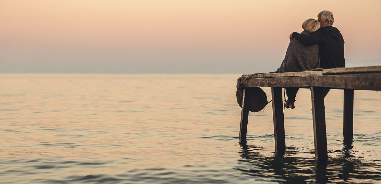 Couple sitting on dock watching the sunset