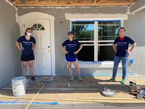 Raymond James Supervision associates pose in front of the newly painted house.