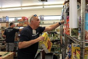 A volunteer stacks cereal in the food pantry