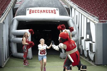 A young girl high-fives Captain Fear as she runs onto the field at Raymond James Stadium