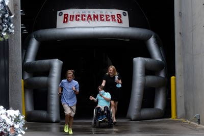 A family comes out onto the field through the Buccaneers tunnel