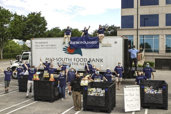 Raymond James associates and advisors practice social distancing while volunteering to load donations into the Mid-South Food Bank truck