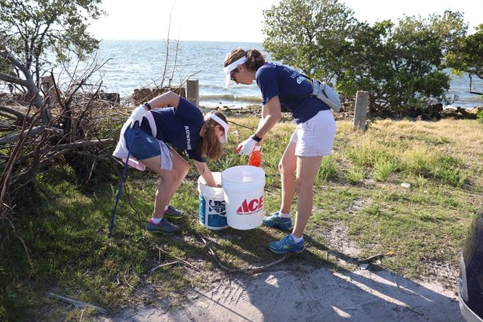 Raymond James associate Samantha Johns and her daughter fill buckets with waste at Gandy Beach.